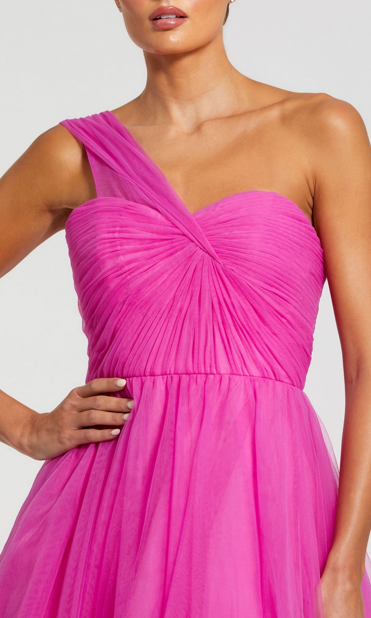 A woman wears the Mac Duggal 68713 One-Strap Long Prom Ball Gown in bright pink, featuring a single shoulder strap, pleated details, a fitted bodice, and a flowing skirt.